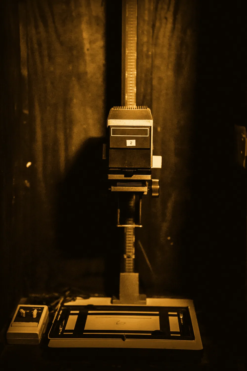An enlarger standing over its easel in the darkroom.